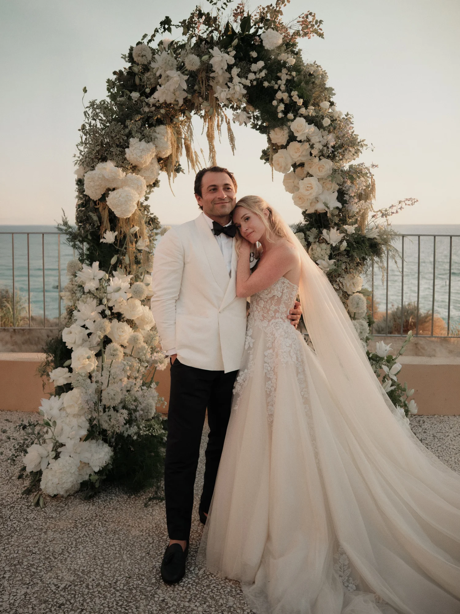Wedding couple beneath a floral arch
